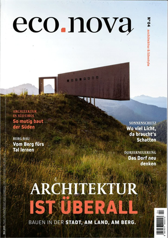Titelblatt Zeitschrift eco.nova, ein grosses Gebäude aus Beton mit kleinen Fenster ragt auf einem Hügel nach vorne, im Hintergrund die Bergketten